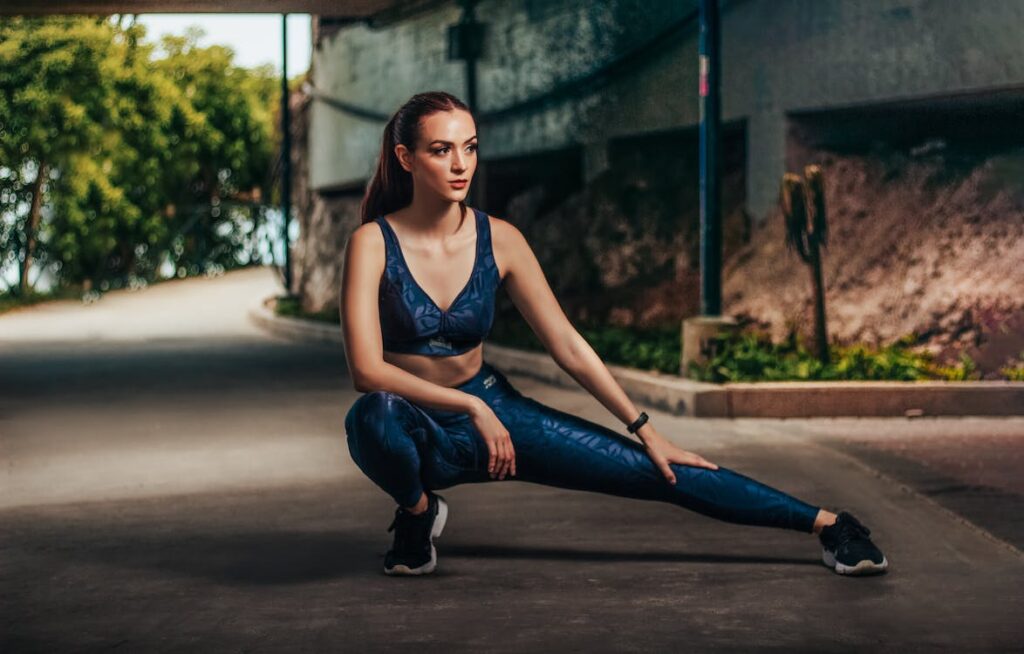 Young woman stretching legs in park